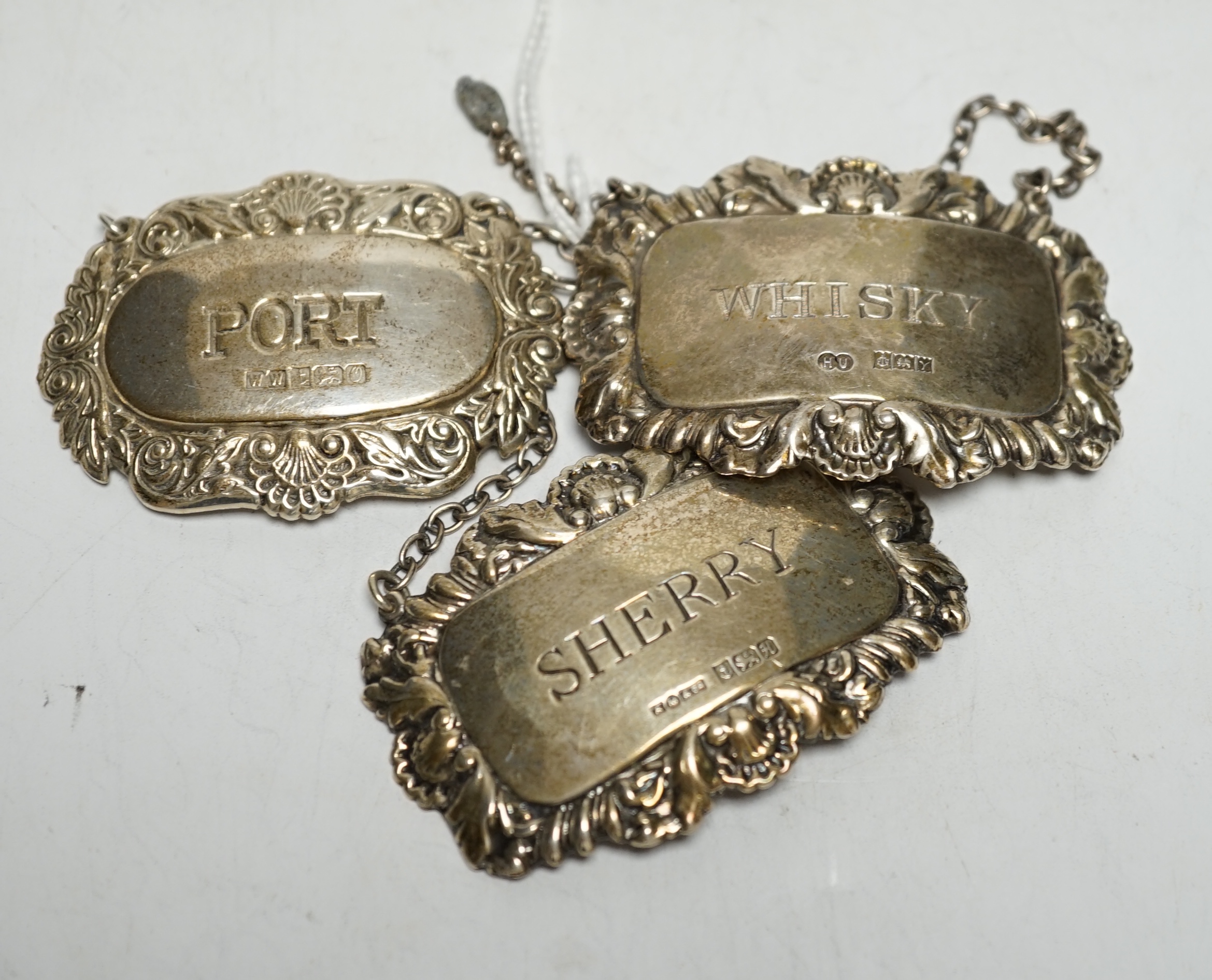 Three assorted modern silver wine labels.